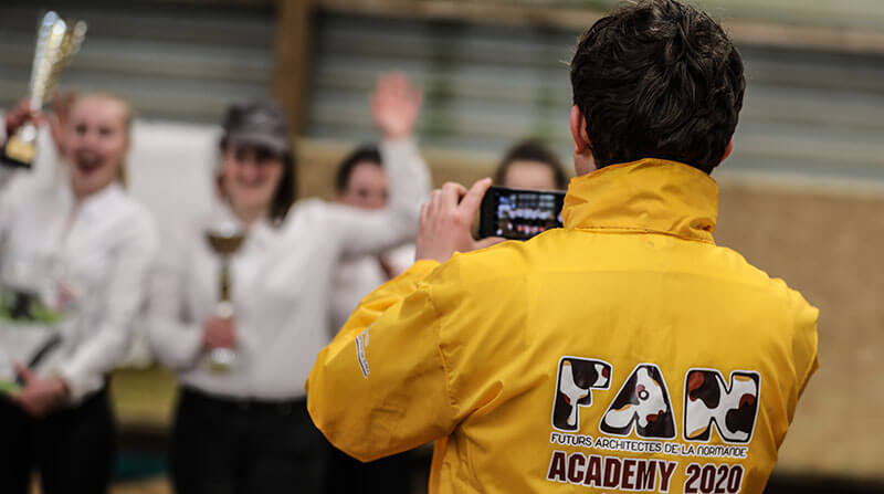 Un photographe avec le K-way de la FAN Academy 2020 prend en photo des jeunes de FAN